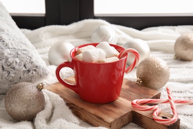 Composition with cup of hot winter drink near window. Cozy season