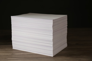 Photo of Stack of paper sheets on wooden table