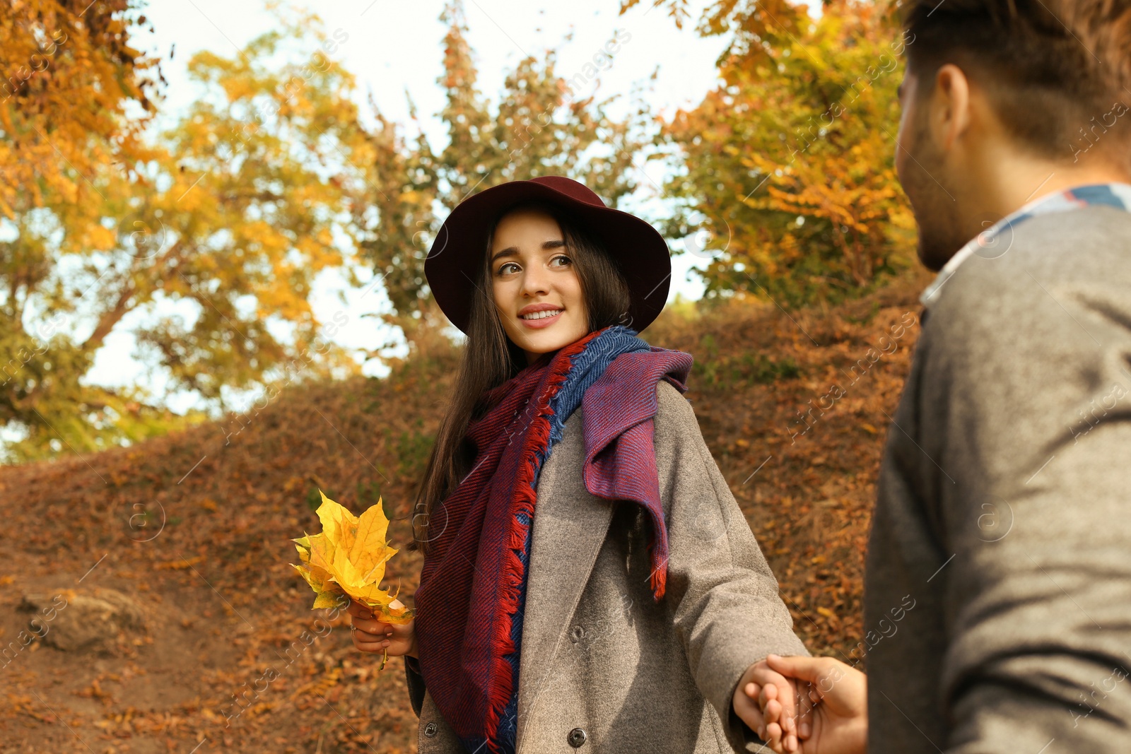 Photo of Young lovely couple spending time together in park. Autumn walk