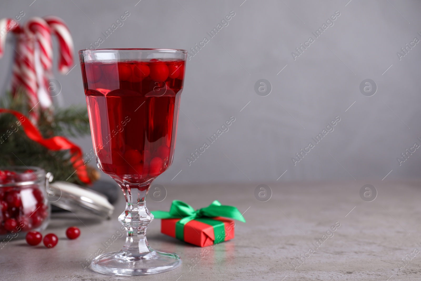 Photo of Delicious Christmas liqueur on grey table, closeup. Space for text