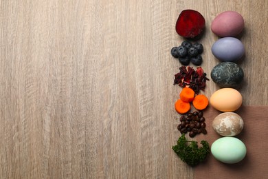 Naturally painted Easter eggs and space for text on wooden table, flat lay. Beetroot, blueberries, hibiscus, carrot, coffee beans, parley used for coloring