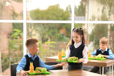 Photo of Happy children with healthy food in school canteen