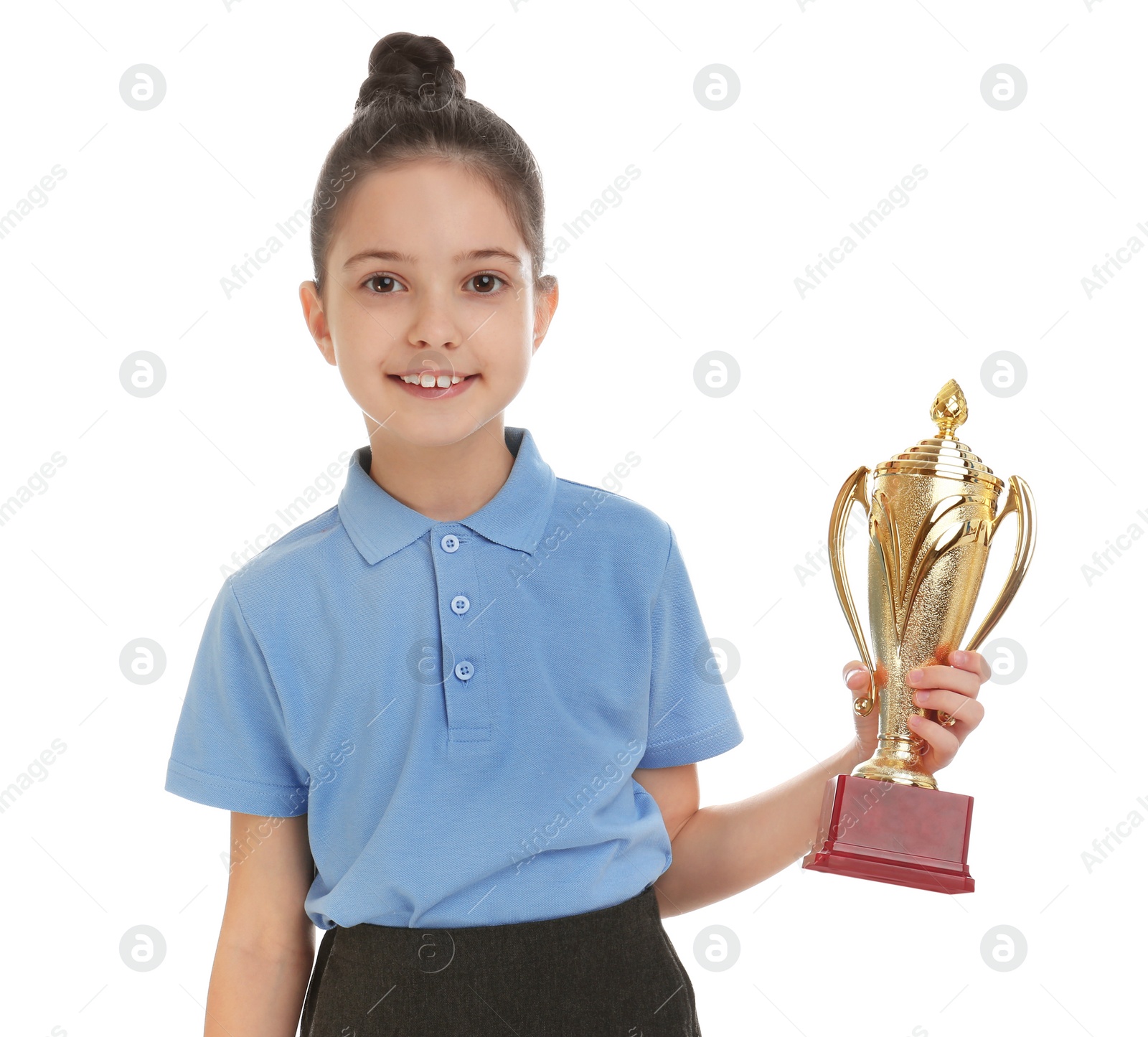 Photo of Happy girl in school uniform with golden winning cup isolated on white