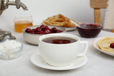 Photo of Cup of hot drink and snacks served on table. Traditional Russian tea ceremony