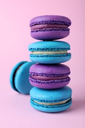 Stack of delicious colorful macarons on pink background