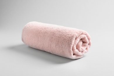 Photo of Fresh soft rolled towel on light background