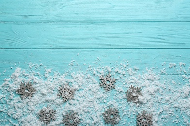 Photo of Flat lay composition with snowflakes on blue wooden background, space for text. Winter season