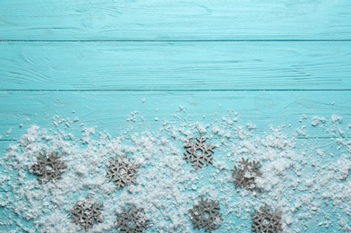 Flat lay composition with snowflakes on blue wooden background, space for text. Winter season