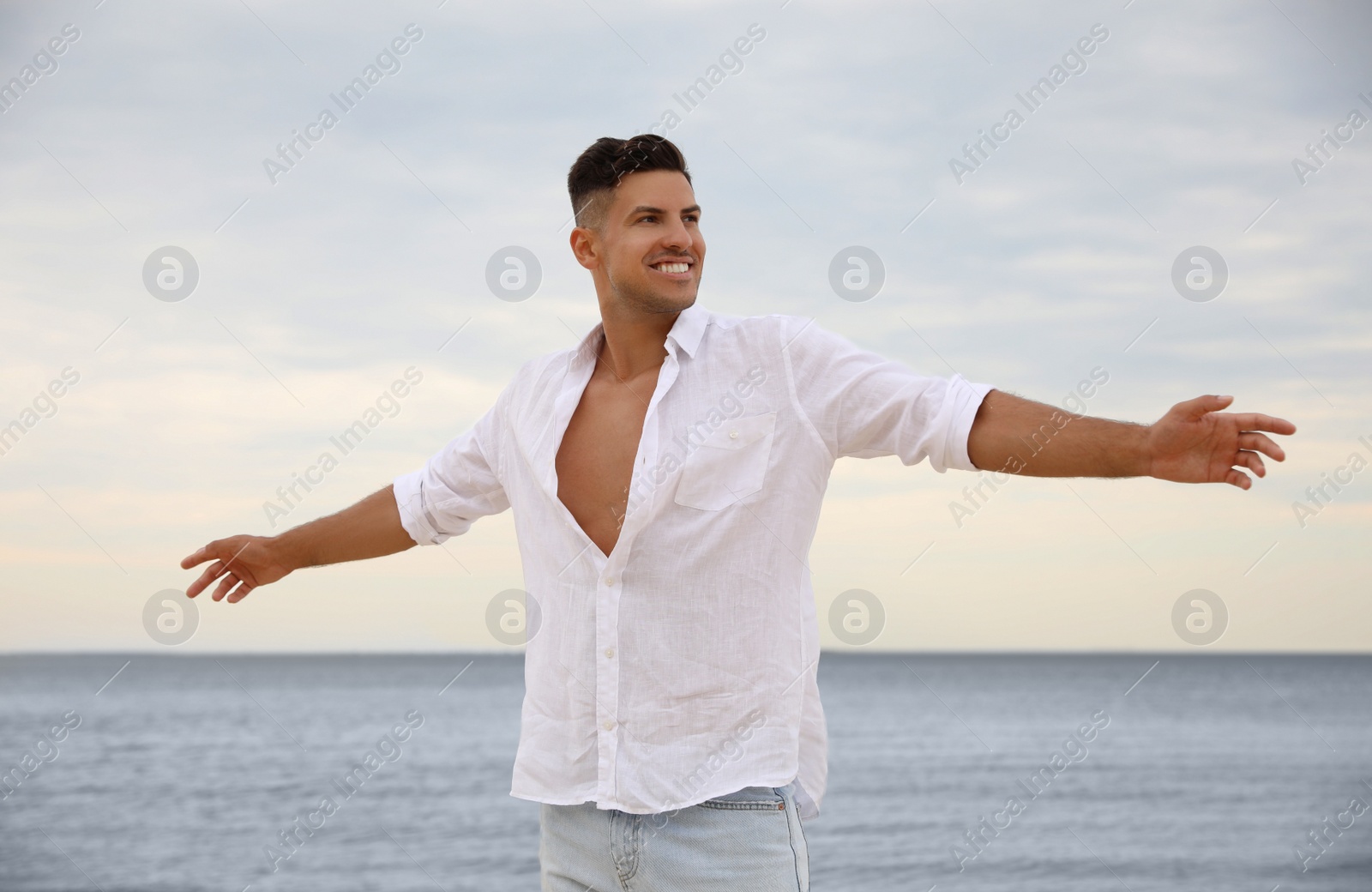 Photo of Handsome man on beach near sea. Summer vacation