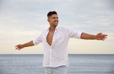 Photo of Handsome man on beach near sea. Summer vacation