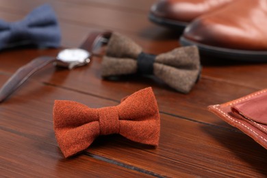 Photo of Stylish bow ties on wooden background, closeup
