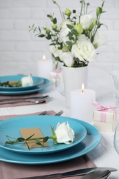 Photo of Elegant festive table setting with blank card in restaurant