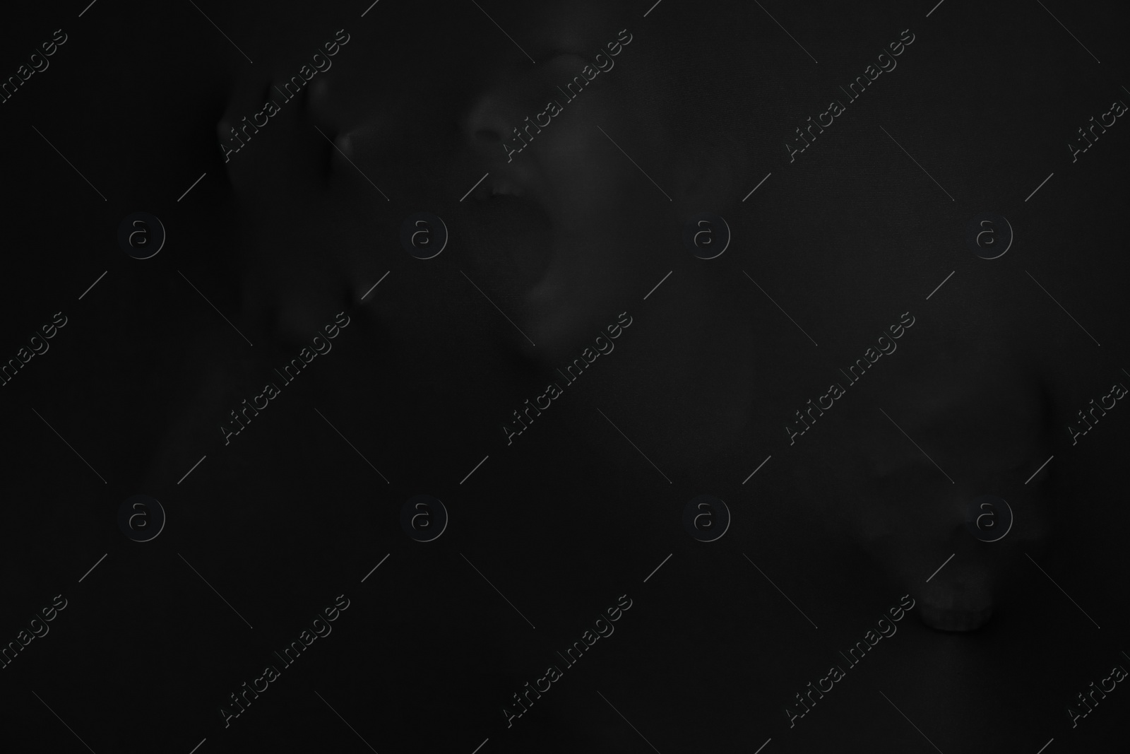 Photo of Silhouette of creepy ghost with skull behind black cloth