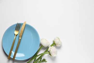 Photo of Stylish table setting with cutlery and flowers on white background, flat lay. Space for text