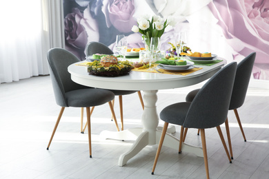 Photo of Festive Easter table setting with beautiful white tulips and eggs indoors