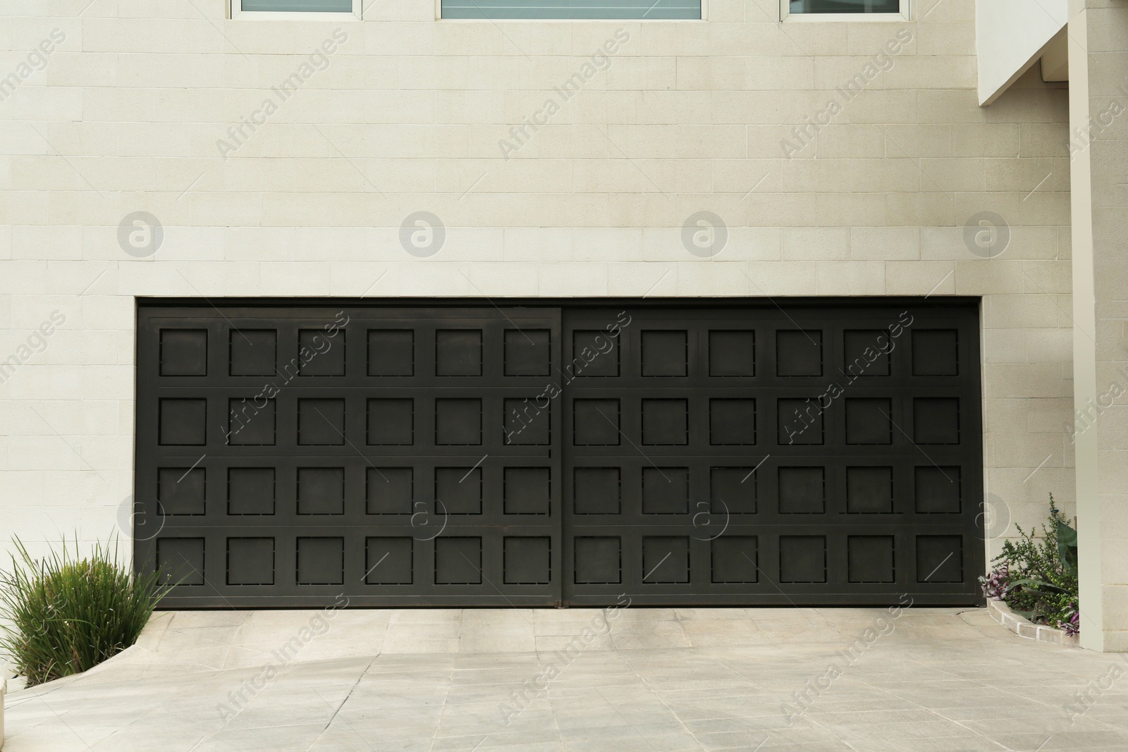 Photo of Building with black sectional garage doors and paved driveway