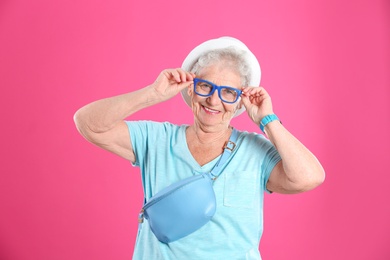 Portrait of cool grandmother on color background