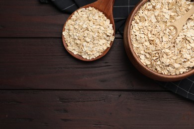 Photo of Bowl with scoop and spoon of oatmeal on wooden table, flat lay. Space for text
