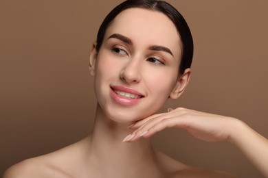 Photo of Portrait of beautiful young woman on brown background