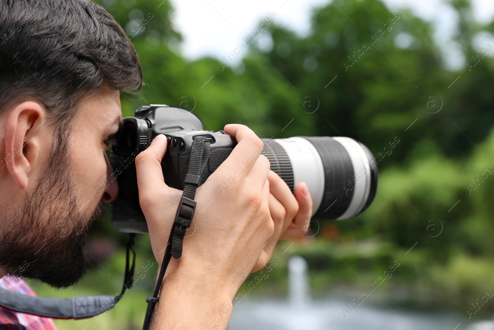 Photo of Photographer taking photo with professional camera in park