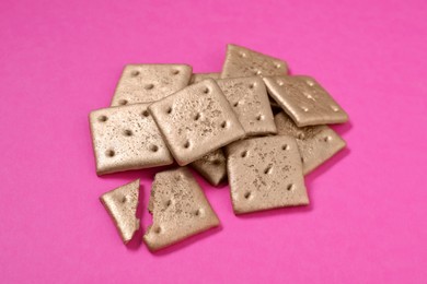 Photo of Pile of golden cookies on pink background