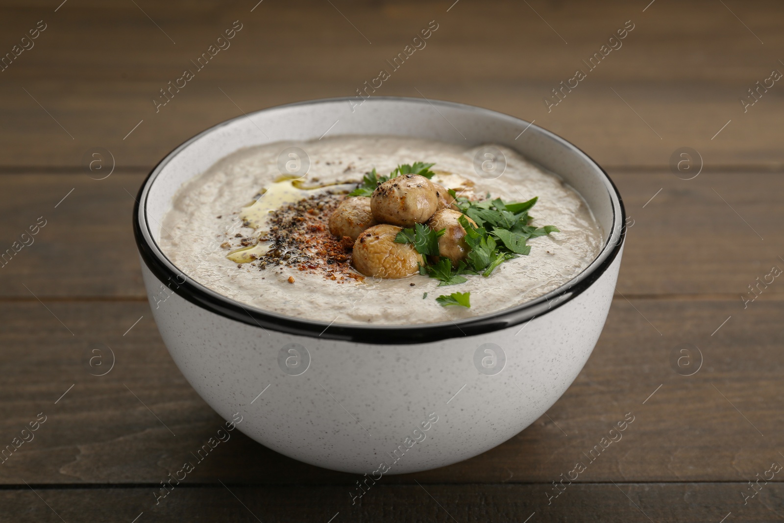 Photo of Delicious cream soup with mushrooms on wooden table