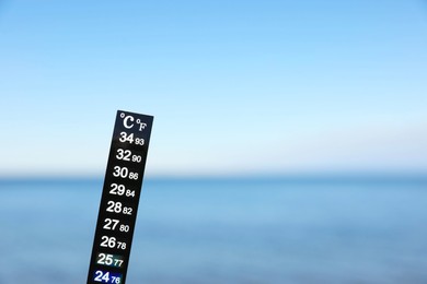 Photo of Weather thermometer at seaside, space for text