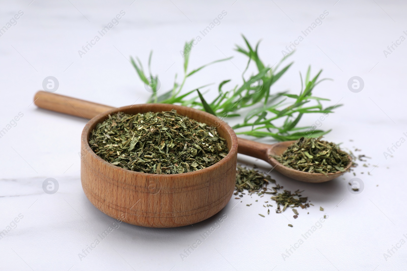 Photo of Dry and fresh tarragon on white table