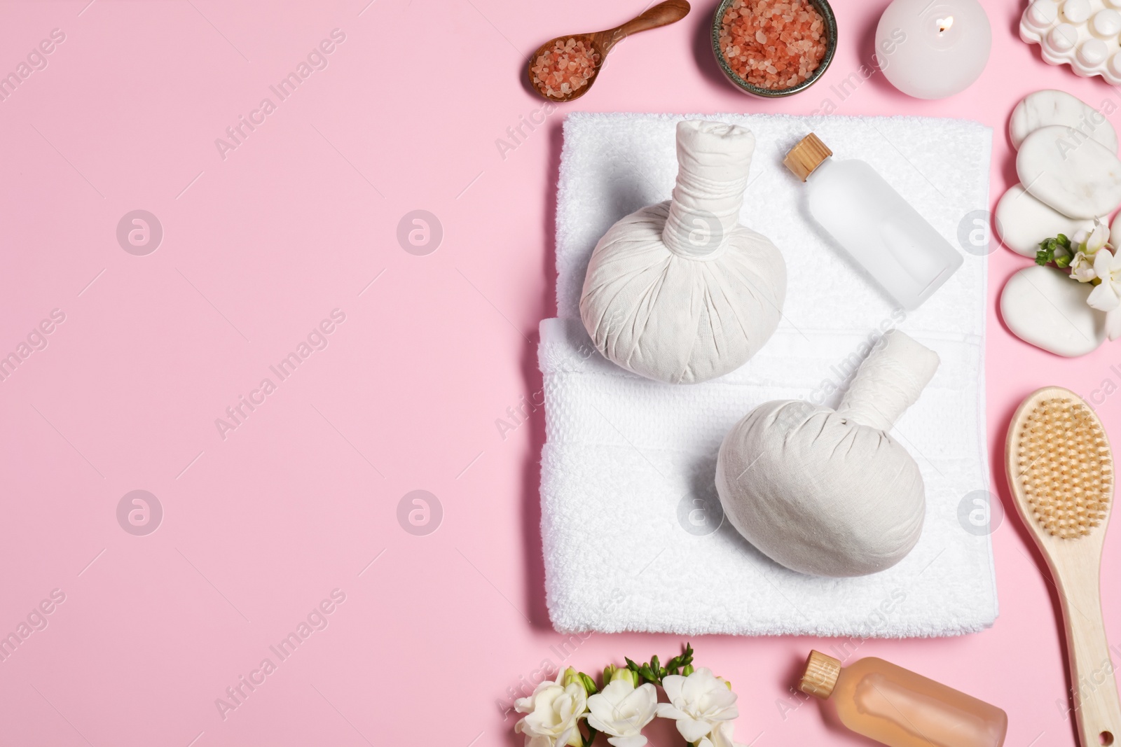 Photo of Flat lay composition with herbal massage bags and other spa products on pink background, space for text