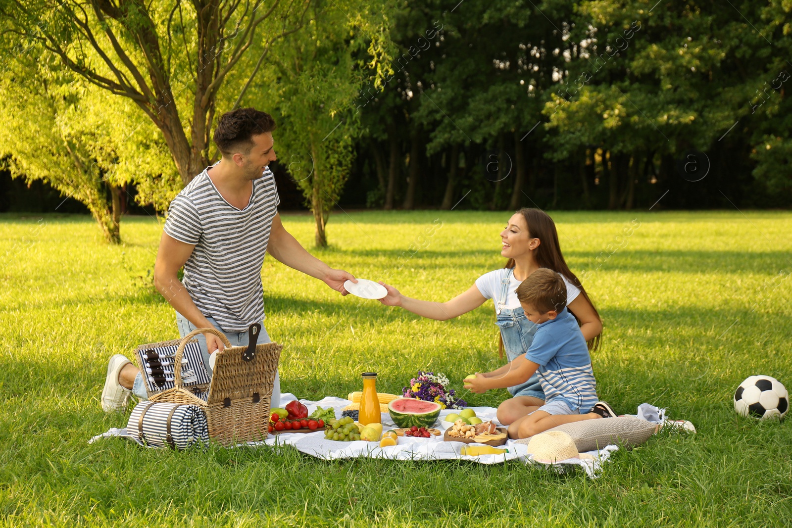 Photo of Happy family having picnic in park on sunny summer day