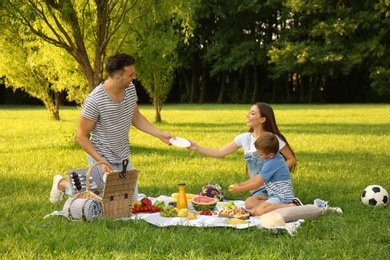 Happy family having picnic in park on sunny summer day