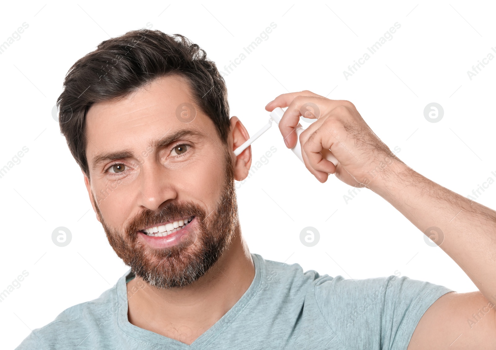 Photo of Man using ear spray on white background