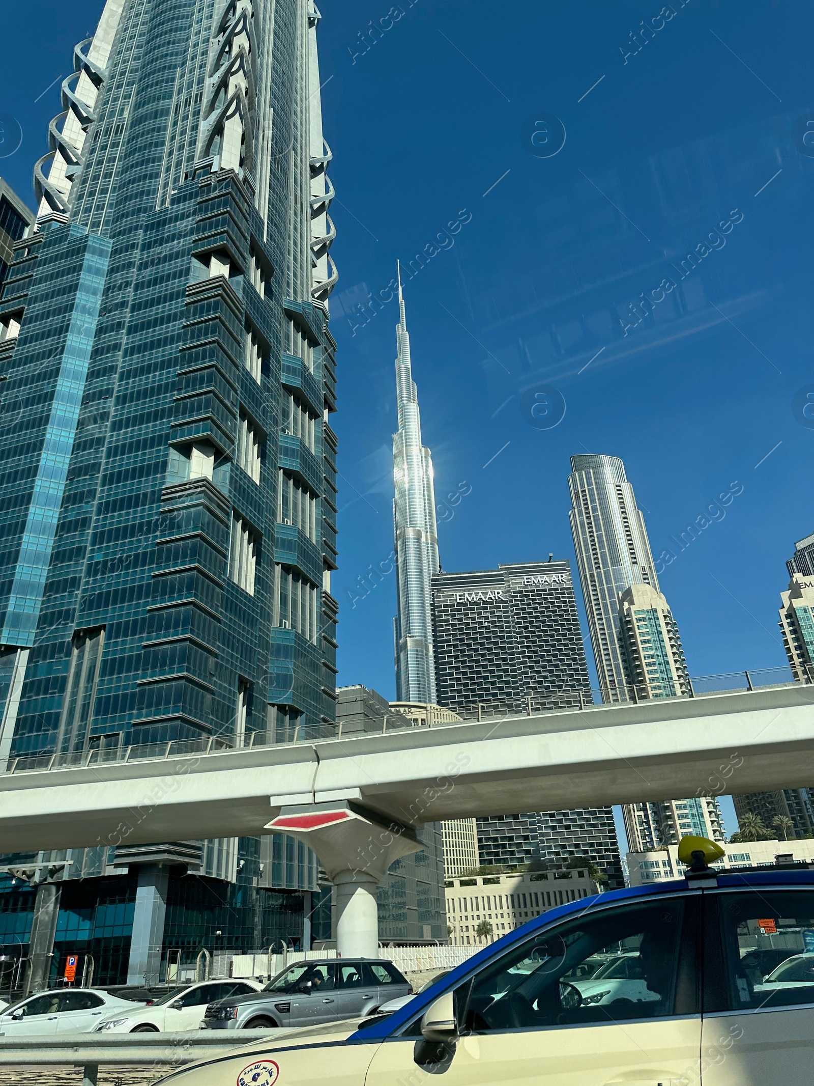 Photo of Dubai, United Arab Emirates - May 2, 2023: Beautiful view of Burj Khalifa and buildings in city under blue sky