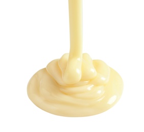 Tasty pouring condensed milk on white background. Dairy product