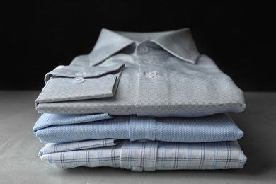 Photo of Stack of classic shirts on light stone table