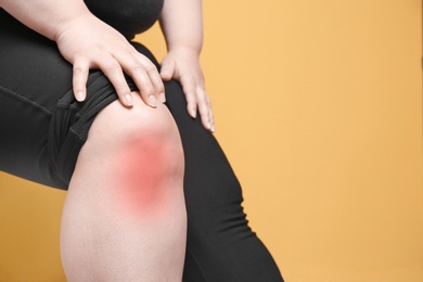 Photo of Overweight woman on color background, closeup of legs