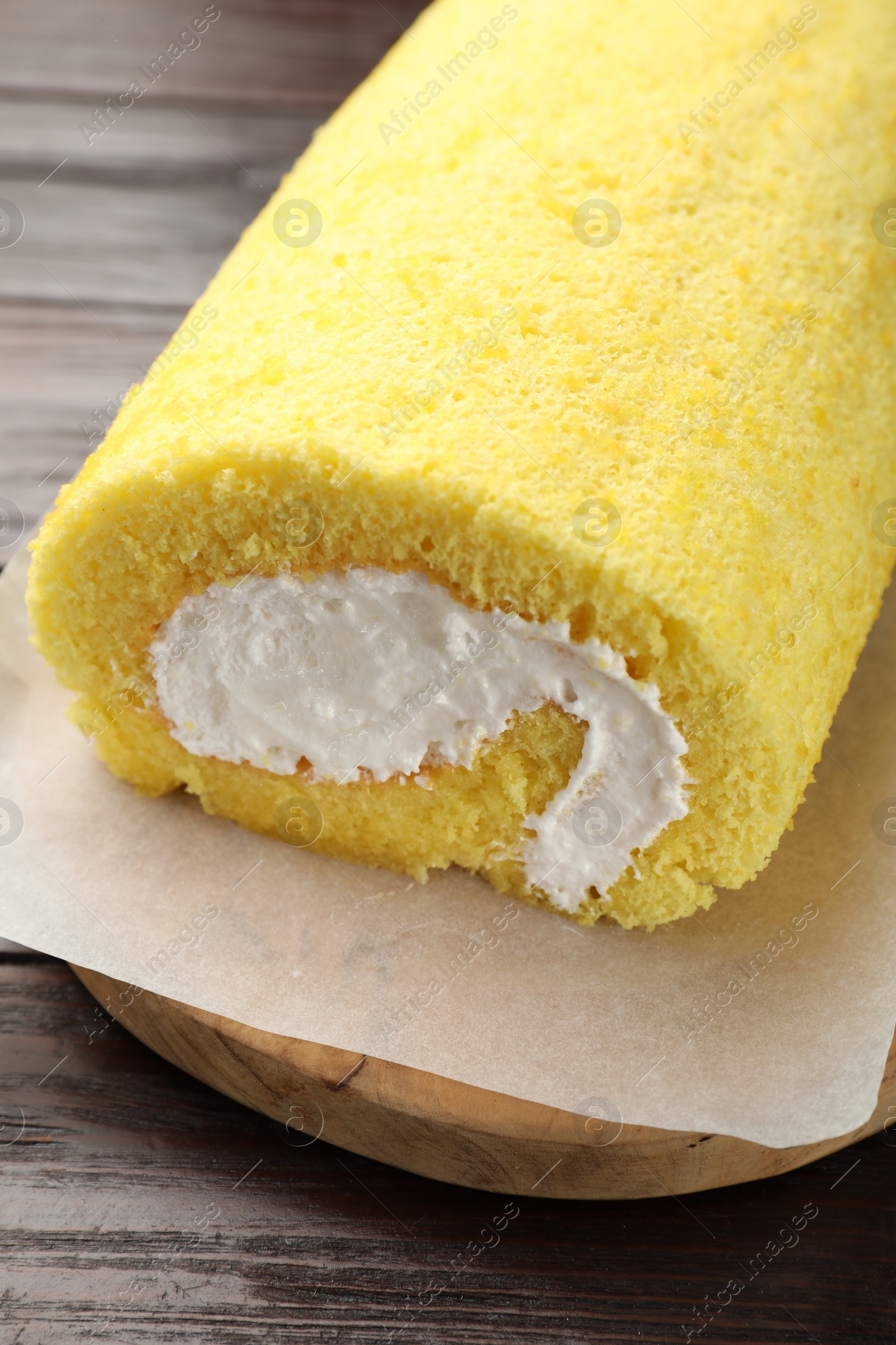 Photo of Delicious cake roll on wooden table, closeup