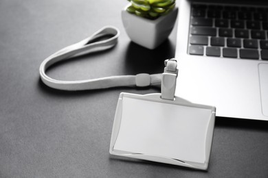 Photo of Blank badge, laptop and houseplant on grey background