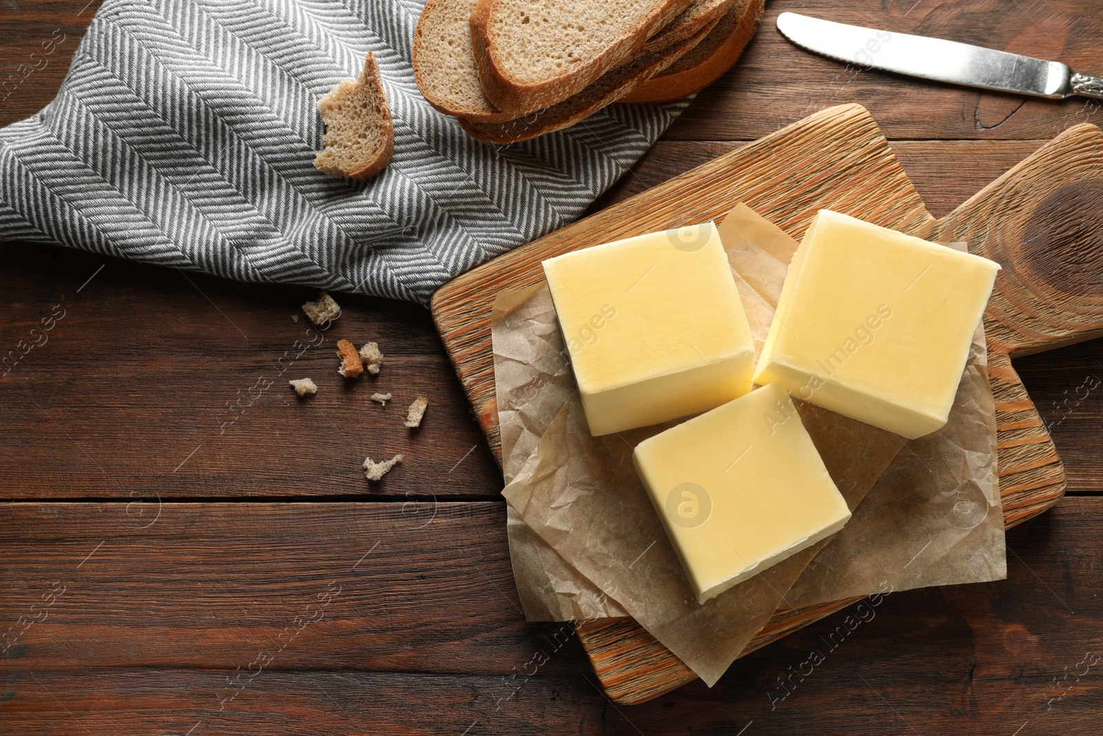 Photo of Wooden board with tasty fresh butter on table, top view