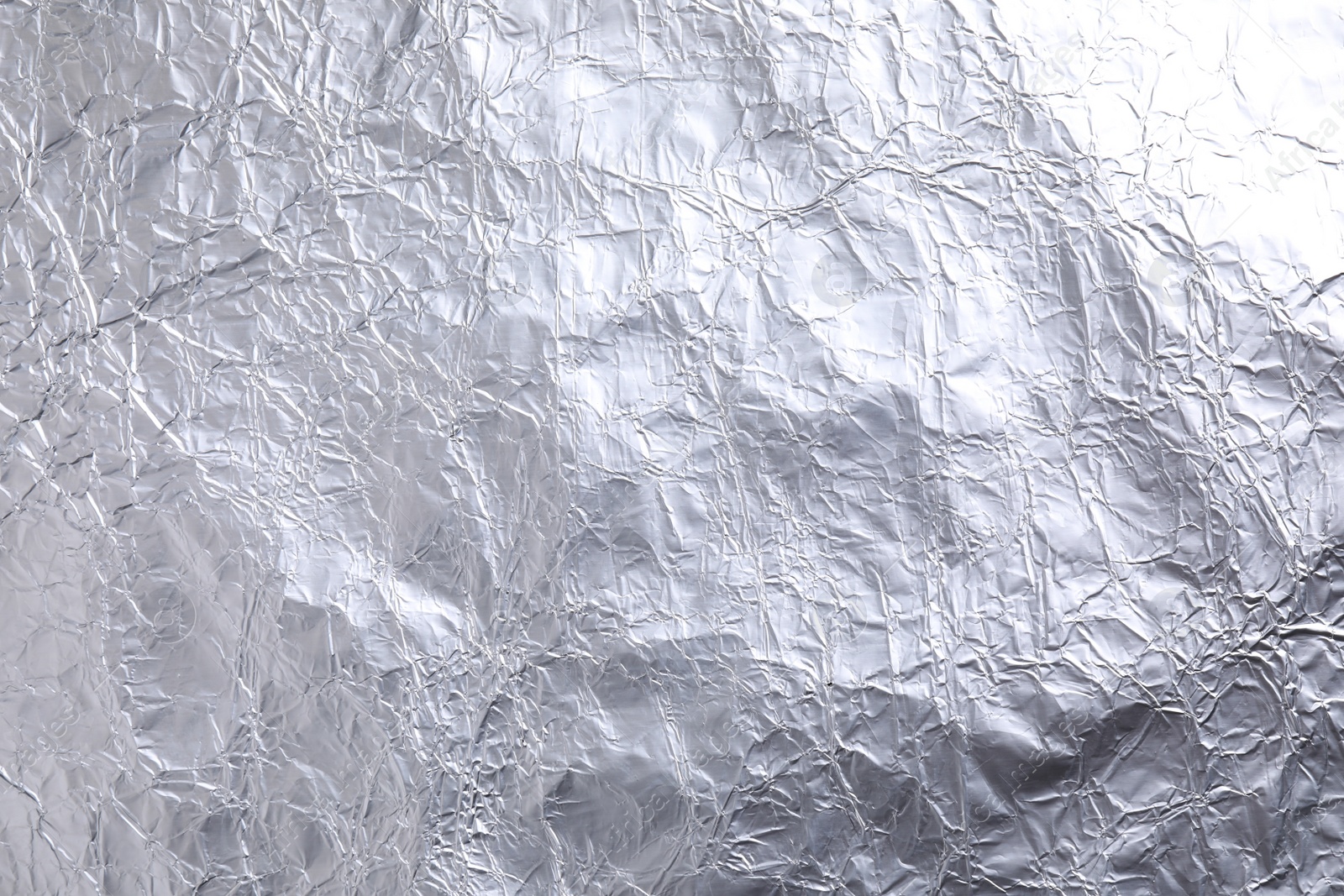 Photo of Crumpled silver foil as background, closeup view