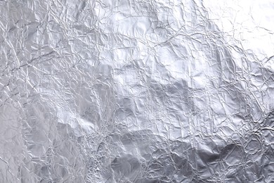 Crumpled silver foil as background, closeup view