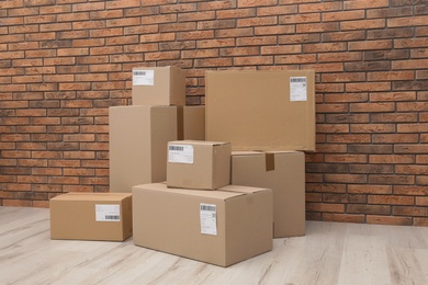 Photo of Stacked parcel boxes on floor against brick wall