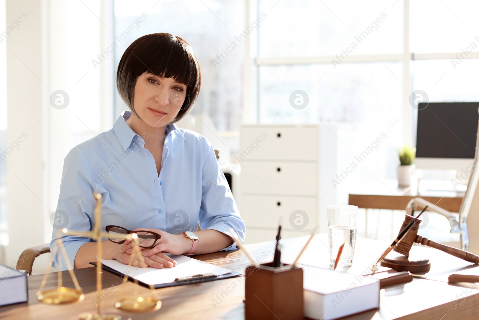 Photo of Female lawyer working at table in office