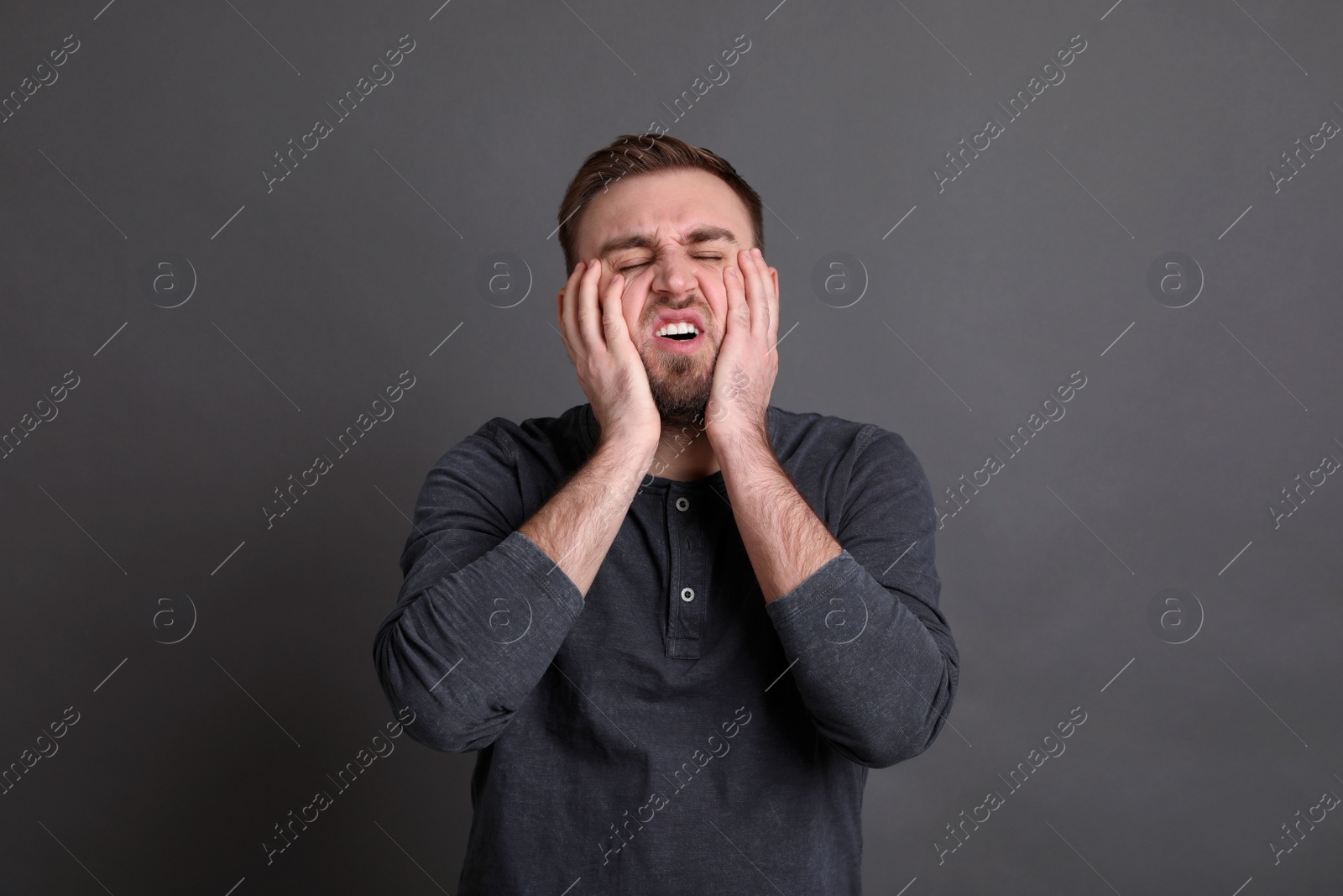 Photo of Portrait of emotional young man on grey background. Personality concept