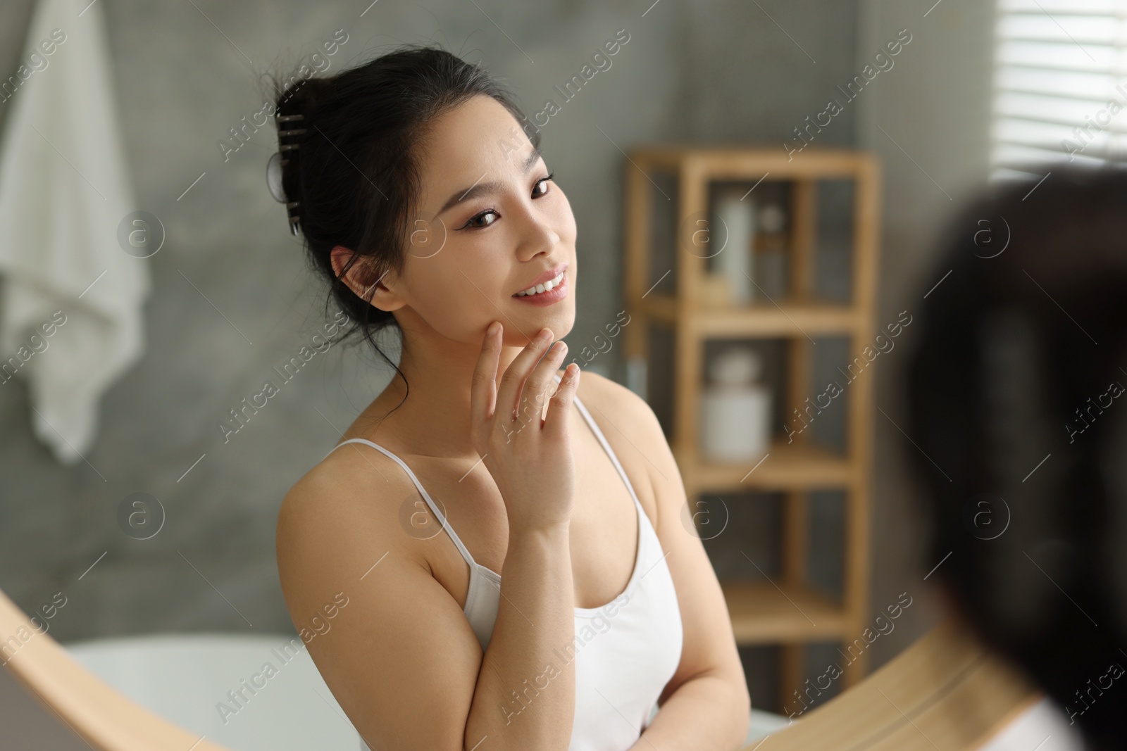 Photo of Portrait of beautiful woman near mirror indoors