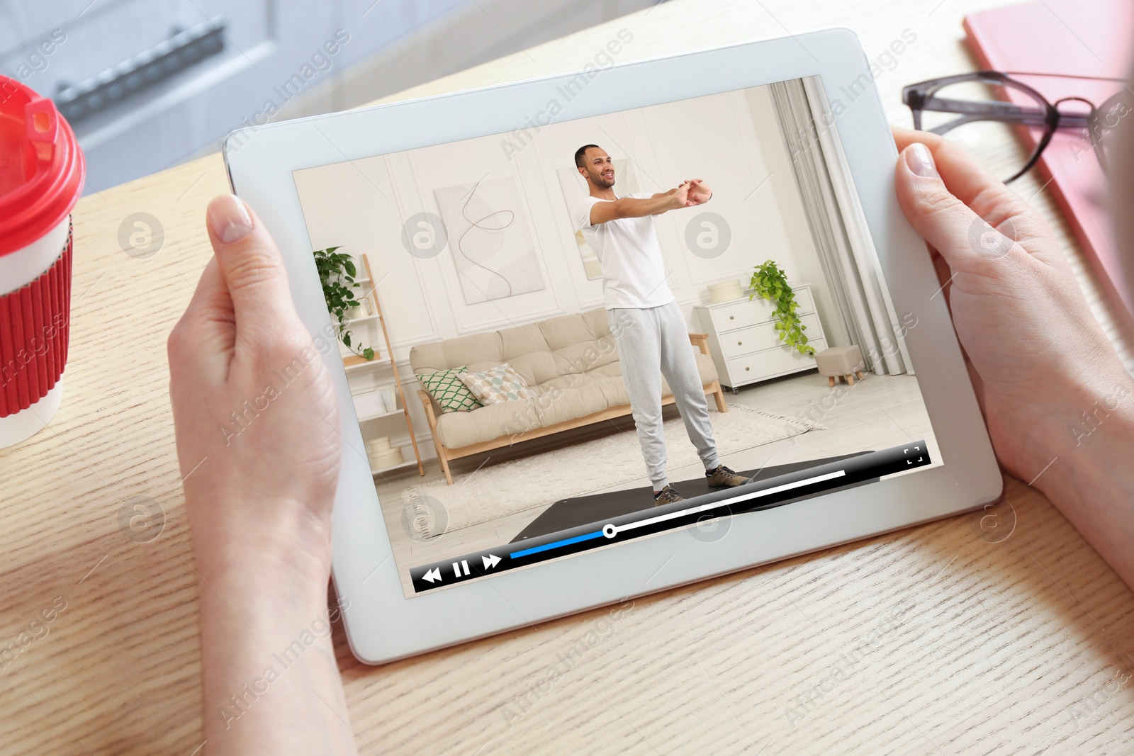 Image of Woman watching morning exercise video on tablet computer at table, closeup