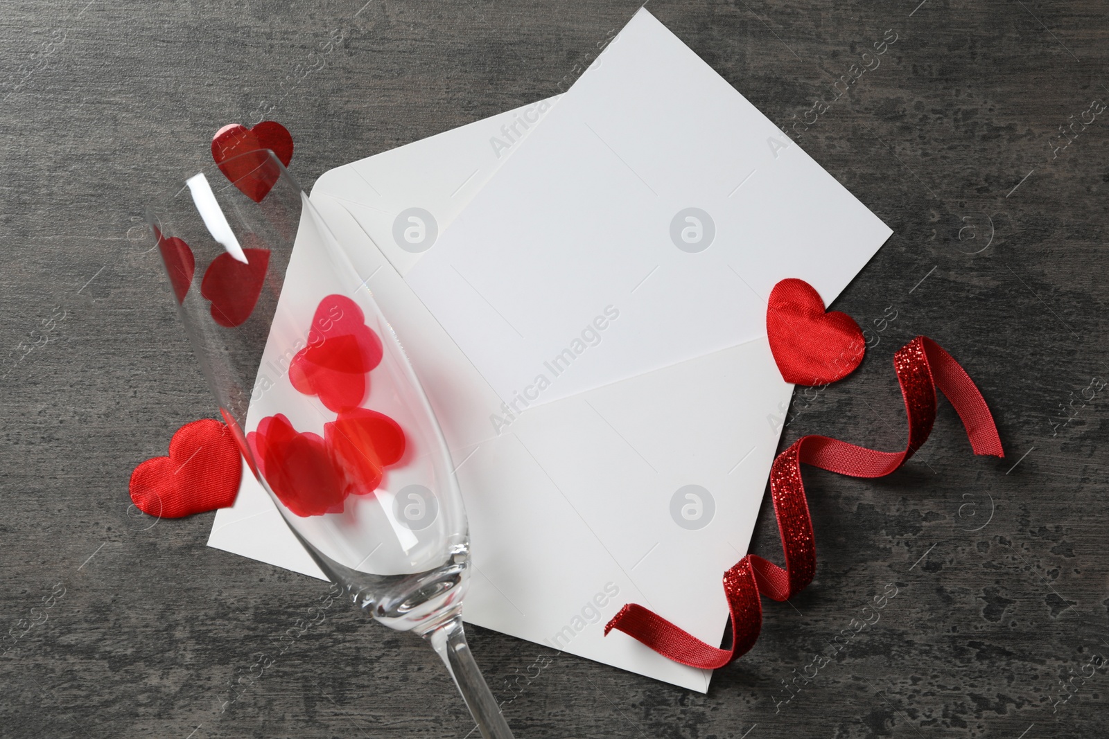 Photo of Flat lay composition with blank card on grey background, space for text. Valentine's Day celebration