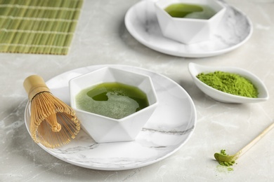 Photo of Bowl of fresh matcha tea and chasen on table