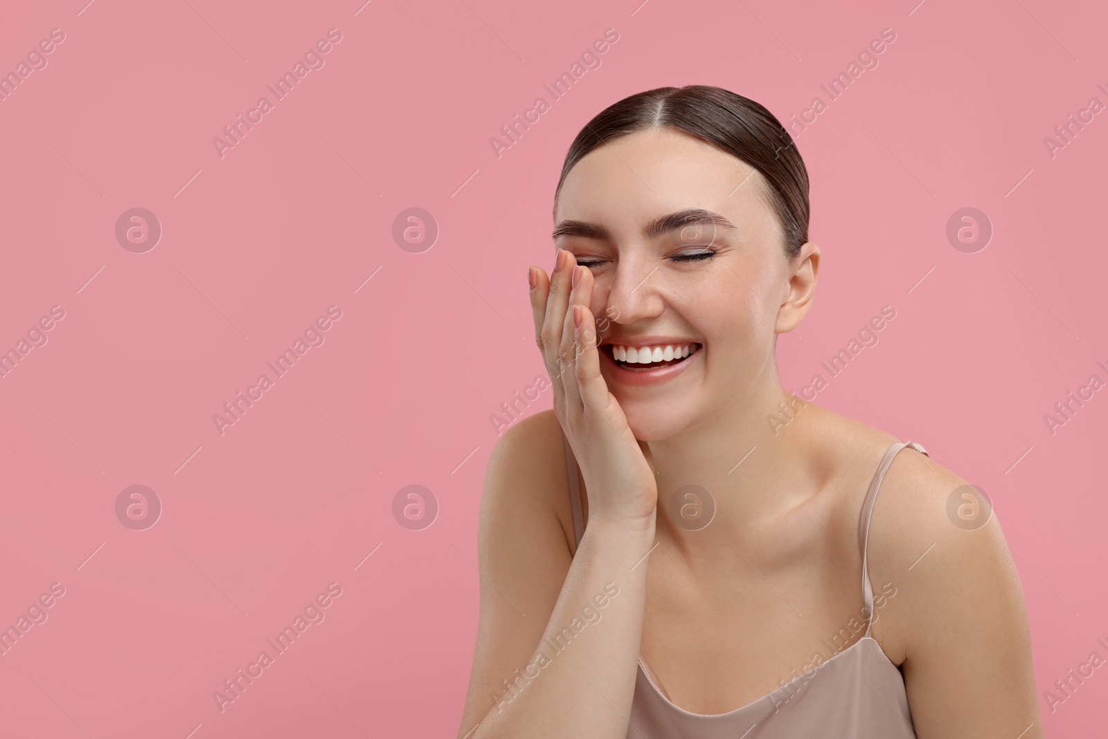 Photo of Beautiful woman laughing on pink background. Space for text