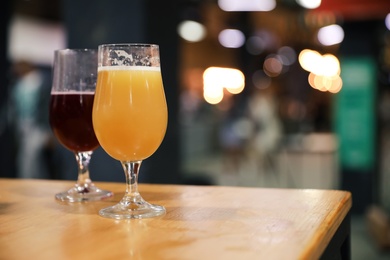 Glasses of beer on wooden table in pub